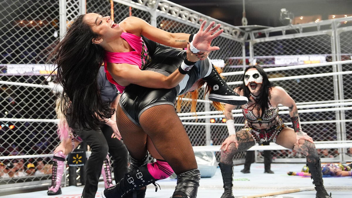 AJ Lee hitting the Black Widow on Becky Lynch with Rhea Ripley watching at WWE Survivor Series WarGames 2025